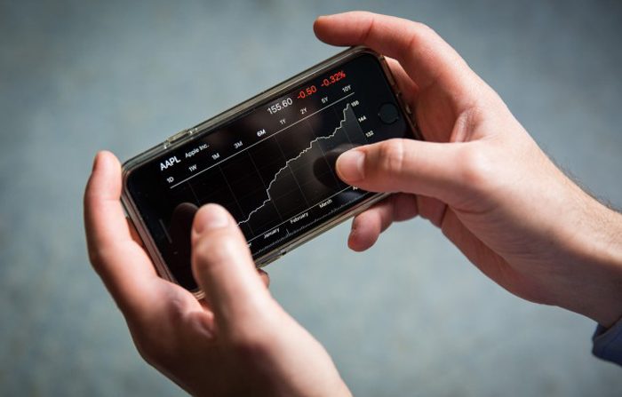 Un uomo guarda sul suo iPhone il  grafico delle azioni di Apple degli ultimi sei mesi, New York il 15 maggio 2017. (Samira Bouaou / The Epoch Times)
