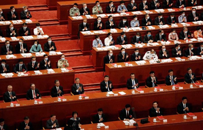 Il leader cinese Xi Jinping e altri funzionari applaudono dopo il voto sulla legge di sicurezza nazionale per la Regione amministrativa speciale di Hong Kong, durante la sessione di chiusura dell'Assemblea nazionale del popolo (Anp) nella la Grande Sala del Popolo a Pechino, Cina, il 28 maggio 2020. (Carlos Garcia Rawlins/Reuters)