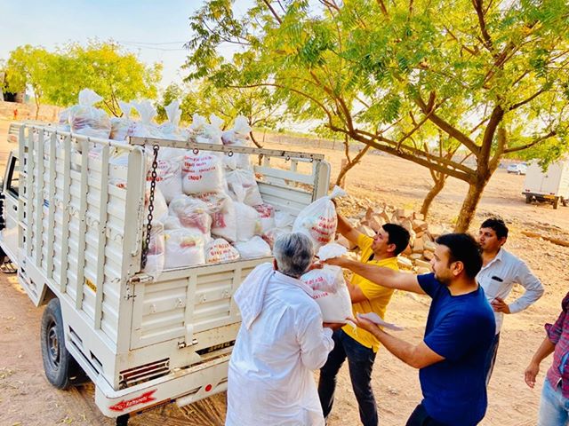 Contadini indiani della famiglia Manda caricano sacchi di cibo su un camion per aiutare i bisognosi durante il lockdown. (Per gentile concessione di Ramnivas Manda)
