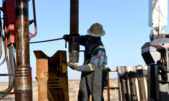Un lavoratore petrolifero rimuove un tappo filettato da un pezzo di tubo di perforazione su un contratto di trivellazione di proprietà di Elevation Resources vicino a Midland, in Texas, il 12 febbraio 2019. (Nick Oxford/Reuters)