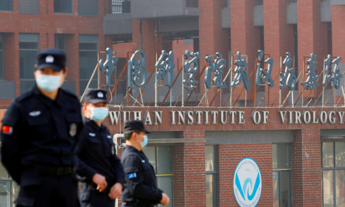 Il personale di sicurezza vigila fuori dall'Istituto di virologia di Wuhan durante la visita del team dell'Organizzazione mondiale della sanità (Oms) incaricato di indagare sulle origini della malattia del coronavirus (Covid-19), a Wuhan, provincia di Hubei, Cina, il 3 febbraio, 2021. (Thomas Peter/Reuters)