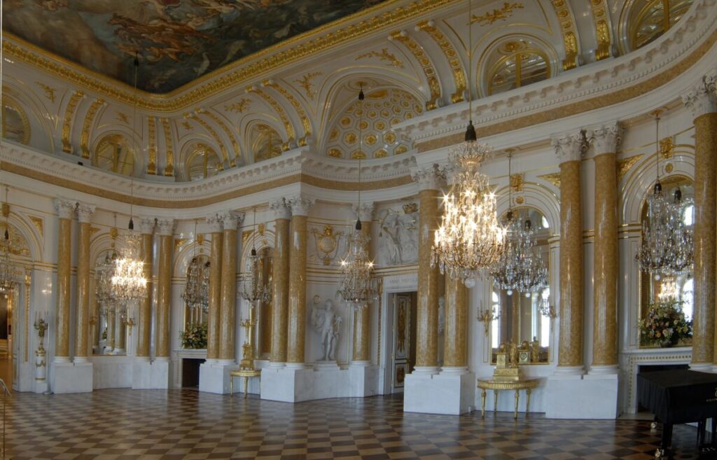 Gli architetti classici Domenico Merlini e Johann Christian Kammsetzer hanno creato un’ariosa e illuminata Grande Sala delle Assemblee. Tra le sue mura bianche, stucchi dorati e colonne luccicanti, gli ospiti un tempo frequentavano feste, balli, concerti e cerimonie di corte. Gli artisti impiegarono quattro anni per decorare la sala con temi che raffigurano le leggi della Polonia e le responsabilità del re. Per esempio, il dipinto nel soffitto La dissoluzione del caos glorifica le riforme del re per portare stabilità alla Polonia dopo anni di tumulti. (A. Ring/castello reale di Varsavia)