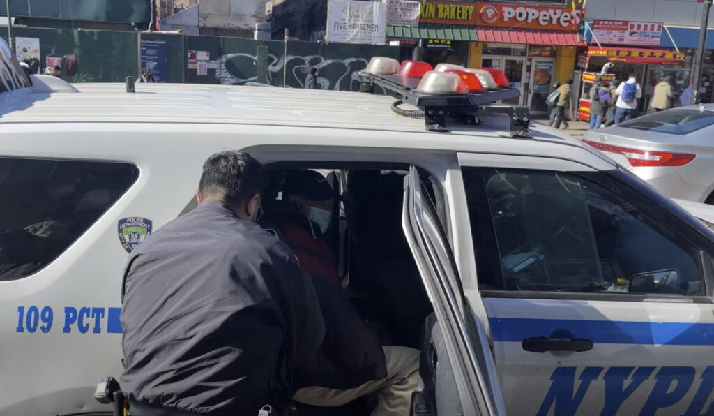 La polizia arresta Qi Zhongping, accusato per aggressione dei praticanti del Falun Gong nel quartiere Flushing del Queens, New York, 18 febbraio 2023. (Schermata via Epoch Times)