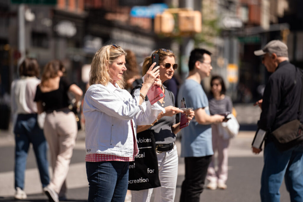 I passanti scattano delle foto mentre i praticanti del Falun Gong celebrano la Giornata Mondiale della Falun Dafa a New York il 7 maggio 2023. (Samira Bouaou/The Epoch Times)