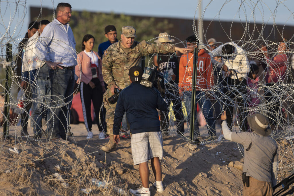 Un soldato della Guardia Nazionale del Texas impedisce ai giornalisti di avvicinarsi ai migranti che hanno attraversato il Messico, a El Paso, in Texas, il 9 maggio 2023. (John Moore/Getty Images)