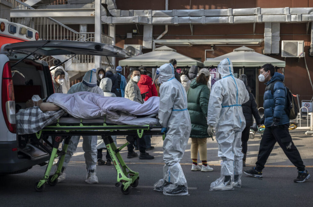 Operatori sanitari arrivano con un paziente su una barella in una clinica per la febbre a Pechino il 9 dicembre 2022. (Kevin Frayer/Getty Images)