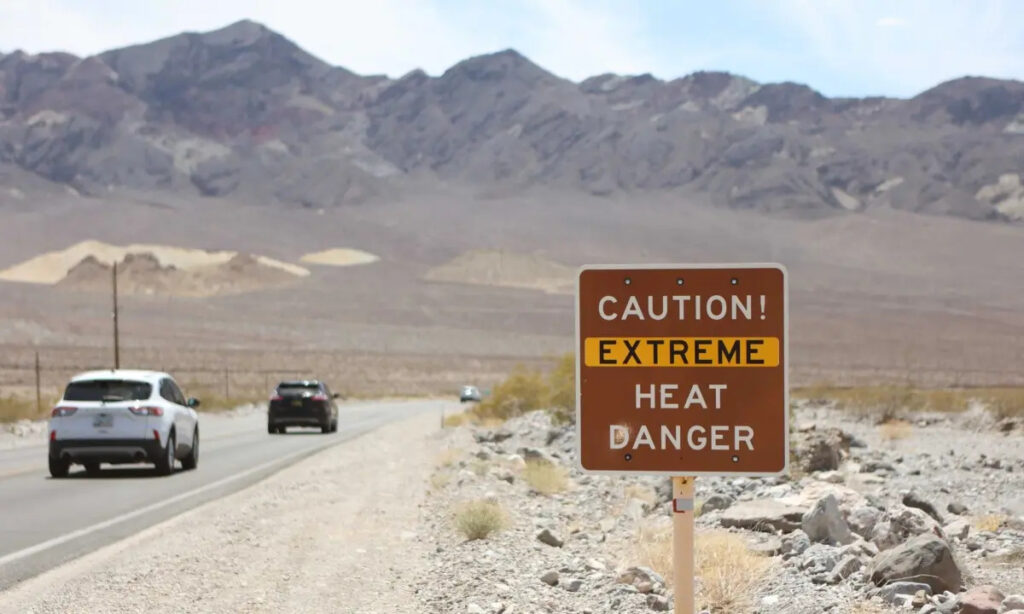 Un cartello di avviso di calore viene mostrato lungo l'autostrada statunitense 190 durante un'ondata di caldo nel Death Valley National Park nella Death Valley, in California, il 16 luglio 2023. (Ronda Churchill/AFP via Getty Images)