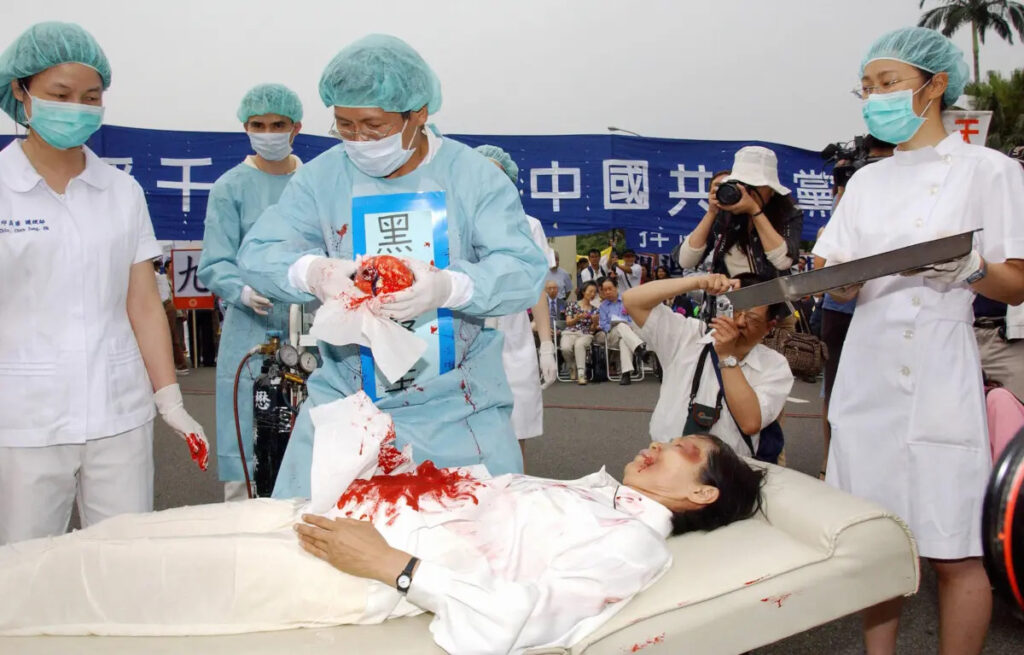 Praticanti del Falun Gong durante una rievocazione della pratica del Partito Comunista Cinese del prelievo forzato di organi dai praticanti del Falun Gong, durante una manifestazione a Taipei, Taiwan, il 23 aprile 2006. (Patrick Lin/AFP via Getty Images)