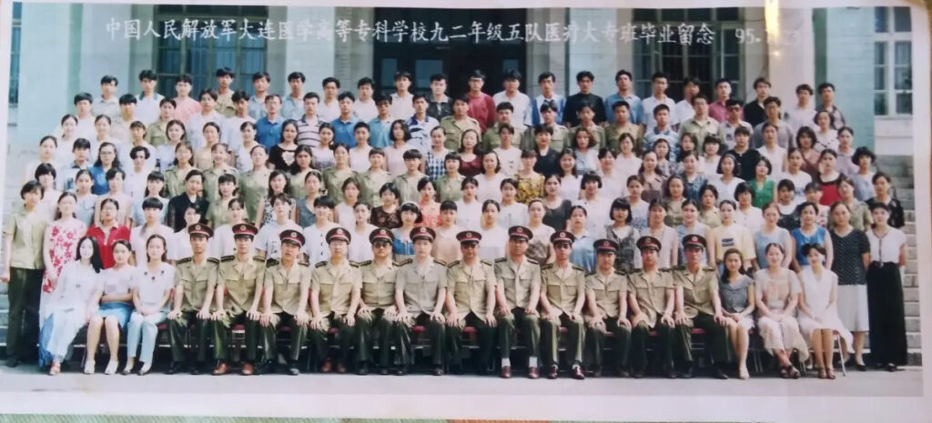 Zheng Zhi (settimo in alto a sinistra) posa con i suoi compagni di classe per una foto di laurea al Pla Dalian Junior College of Medicine di Dalian, Liaoning, nel 1992. (Per gentile concessione di Zheng Zhi)