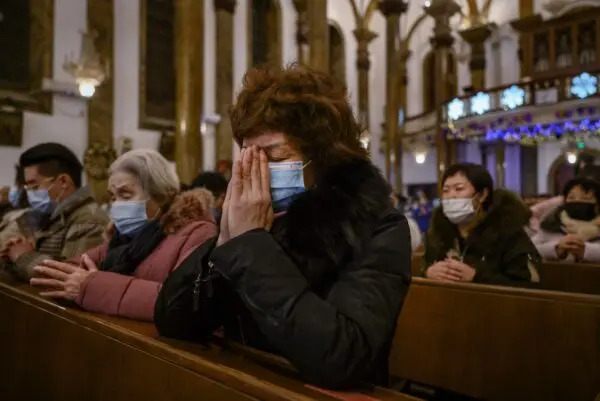 Cristiani cinesi pregano durante una messa di Natale in una chiesa cattolica di Pechino il 24 dicembre 2020. (Kevin Frayer/Getty Images)