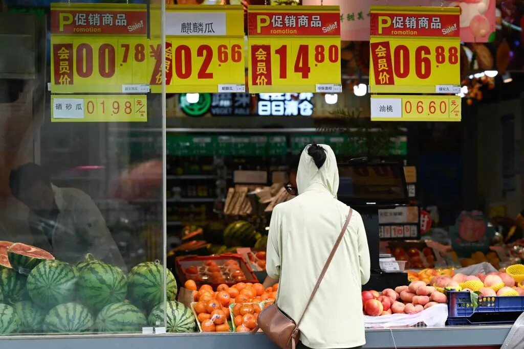 Cliente acquista frutta e verdura in un mercato di Pechino il 9 agosto 2023. (Pedro Pardo/Afp via Getty Images)
