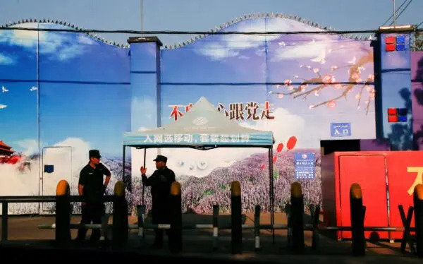 Guardie di sicurezza in piedi ai cancelli di quello che è ufficialmente conosciuto come un centro di formazione professionale nella contea di Huocheng nella regione autonoma uigura dello Xinjiang, in Cina, il 3 settembre 2018. (Thomas Peter/Reuters)