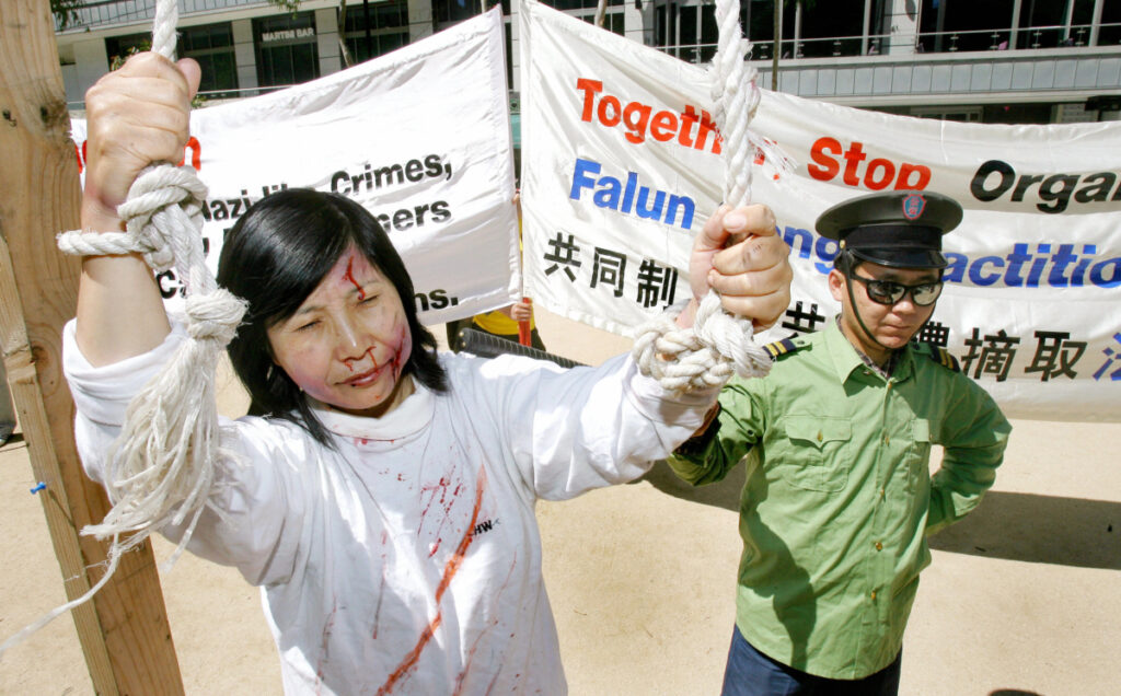 Praticanti del Falun Gong a Melbourne, in Australia, durante una rievocazione della persecuzione dei praticanti della Falun Dafa in Cina il 17 novembre 2006. (WILLIAM WEST/Afp via Getty Images)