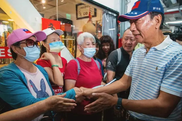Il candidato indipendente alle presidenziali di Taiwan e fondatore di Foxconn Terry Gou (a destra) saluta i sostenitori durante la campagna elettorale in un mercato tradizionale di Taipei l'11 agosto 2023. (Sam Yeh/Afp via Getty Images)