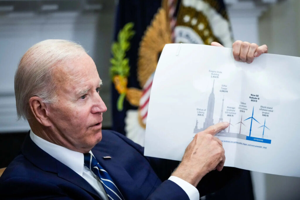 (A sinistra) Il Presidente Joe Biden indica un grafico di una turbina eolica durante un incontro sulla Federal-State Offshore Wind Implementation Partnership alla Casa Bianca il 23 giugno 2022. (A destra) Una balena grigia morta giace sulla riva di Limantour Beach a Point Reyes Station, in California, il 23 maggio 2019. (Drew Angerer/Getty Images, Justin Sullivan/Getty Images)