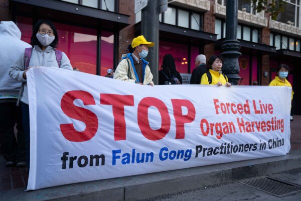 Praticanti del Falun Gong reggono uno striscione a pochi isolati dal Moscone Center per chiedere al leader cinese Xi Jinping, in visita, di porre fine alla pratica del prelievo forzato di organi sanzionata dallo Stato del Pcc, a San Francisco il 14 novembre 2023. (Zhou Rong/The Epoch Times)