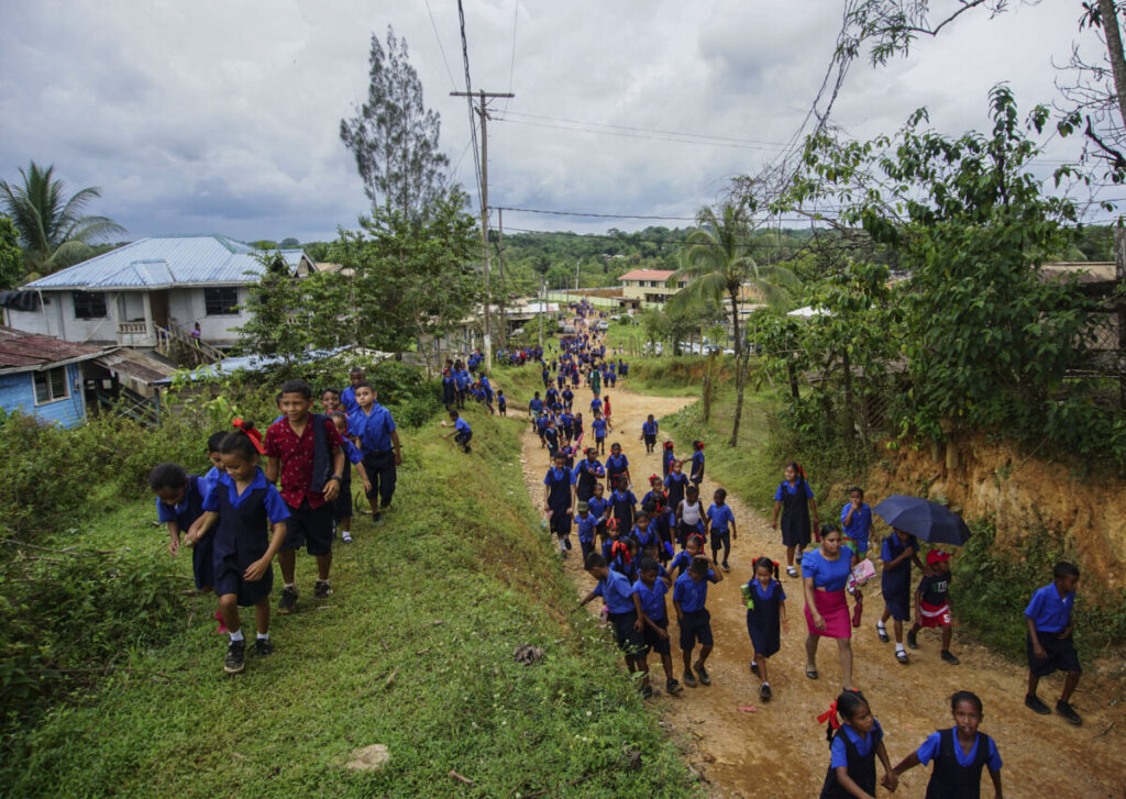 Bambini escono da scuola a Port Kaituma, in Guyana, il 22 settembre 2022. (PATRICK FORT/Afp via Getty Images)