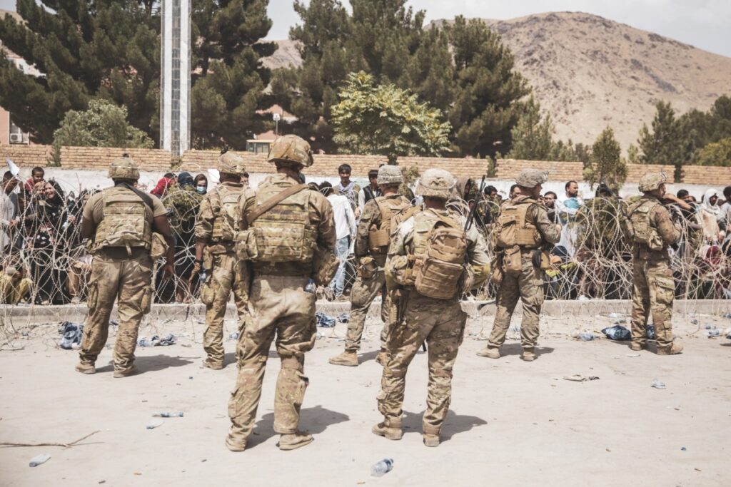 Soldati e Marines statunitensi assistono la sicurezza a un punto di controllo dell'evacuazione durante un'evacuazione all'aeroporto internazionale Hamid Karzai di Kabul, Afghanistan, il 19 agosto 2021. (Staff Sgt. Victor Mancilla/U.S. Marine Corps via Getty Images)
