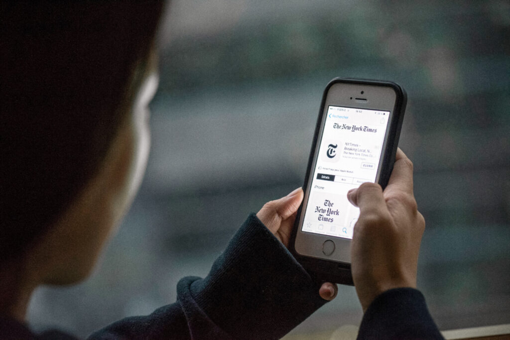 Una persona mostra l'app del New York Times su un dispositivo. Apple ha rimosso il New York Times dal suo app store cinese, dopo che le autorità hanno comunicato all'azienda che l'app violava le norme. (Fred Dufour/Afp via Getty Images)