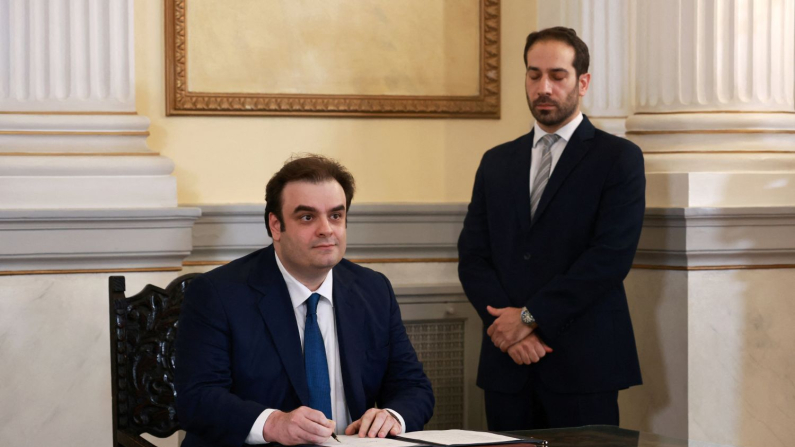 Il ministro delle Finanze greco Kyriakos Pierrakakis firma un documento durante la cerimonia di giuramento dei nuovi membri del governo presso il Palazzo presidenziale di Atene, Grecia, il 15 marzo 2025. (Louiza Vradi/Reuters)
