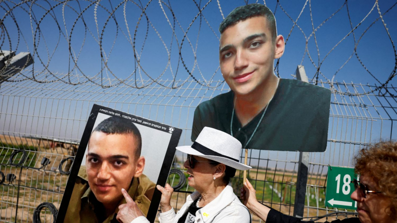 Varda Ben Baruch tiene in mano le foto del nipote Edan Alexander durante una manifestazione delle famiglie degli ostaggi, vicino al confine con la Striscia di Gaza a Nir Oz, Israele, il 20 aprile 2025. (REUTERS/Amir Cohen/File Photo)