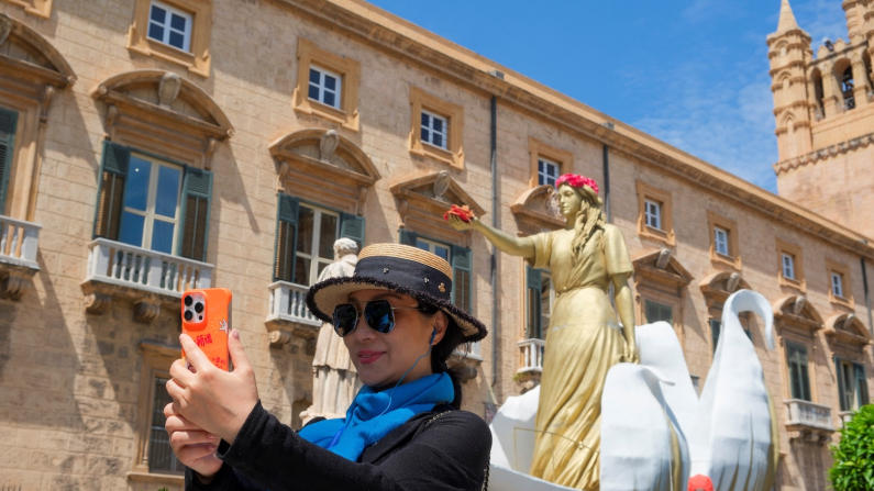 Turista si scatta un davanti alla Cattedrale di Palermo
(foto REUTERS/Igor Petyx).