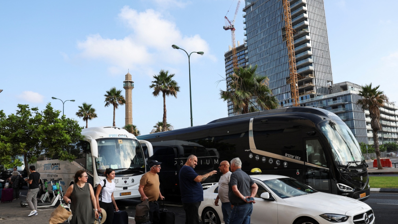 Torna la normalità. Passeggeri aspettano di salire a bordo di un autobus diretto all'aeroporto internazionale Ben Gurion, 24 giugno 2025 (foto REUTERS/Violeta Santos Moura).