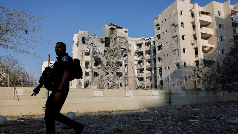 Un militare israeliano passa accanto a un sito residenziale colpito, in seguito a un attacco missilistico dell'Iran contro Israele, a Be'er Sheva, 24 giugno 2025 (foto REUTERS/Amir Cohen)