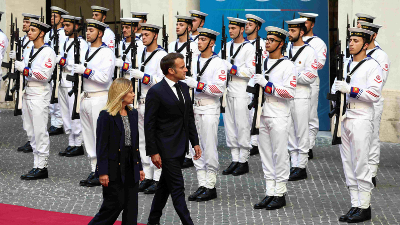 Il presidente francese Emmanuel Macron e il primo ministro italiano Giorgia Meloni passano davanti alla guardia d'onore, il 3 giugno 2025. REUTERS/Guglielmo Mangiapane