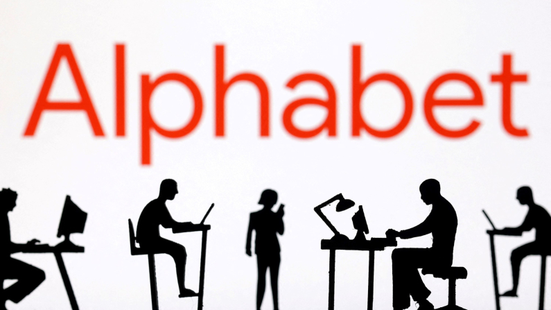 In questa illustrazione scattata il 19 febbraio 2024, si vedono delle statuette con computer e smartphone davanti al logo dell'Alphabet. REUTERS/Dado Ruvic/Illustrazione