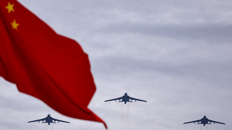 I bombardieri a reazione Xian H-6N volano in formazione oltre una bandiera nazionale cinese durante una prova di sorvolo prima di una parata militare per celebrare l'80° anniversario della fine della seconda guerra mondiale, a Pechino , Cina, 24 agosto 2025. (REUTERS/Tingshu Wang)

