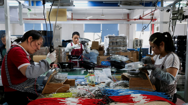 I dipendenti della Gstar Electronic Appliance Co., Ltd lavorano all'assemblaggio di friggitrici ad aria nella fabbrica di Ningbo, provincia di Zhejiang, Cina, 19 maggio 2025. Foto: REUTERS/Go Nakamura/Foto d'archivio