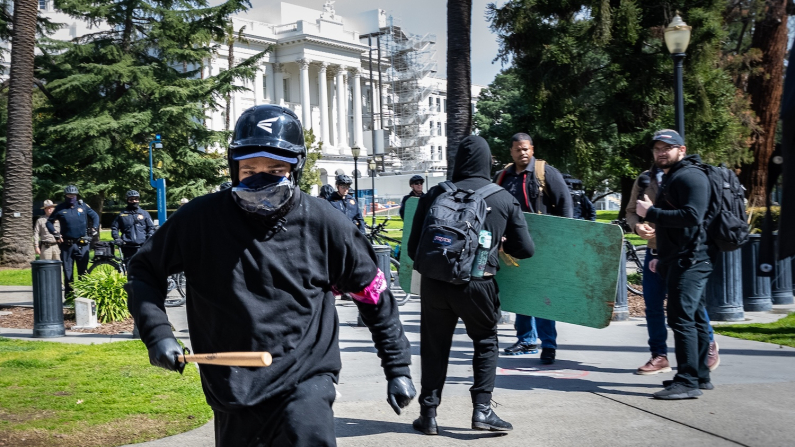 Gli attivisti Antifa riunitisi di fronte all'edificio del Parlamento dello Stato della California, attaccano un gruppo di giornalisti. Sacramento, il 10 marzo 2023 (foto: John Fredricks/The Epoch Times).
