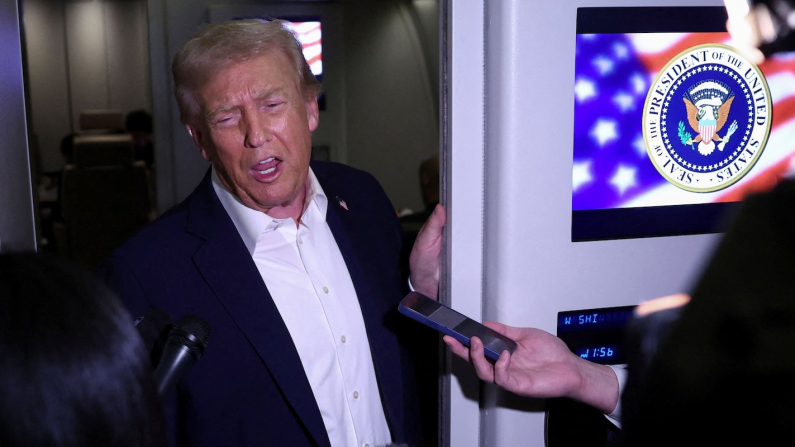 Donald Trump risponde ai giornalisti   a bordo dell'Air Force One (foto REUTERS/Evelyn Hockstein).