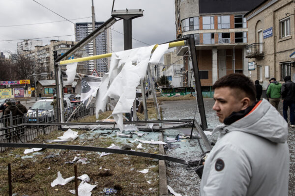 Civili attorno a una struttura danneggiata da un razzo a Kiev, in Ucraina, il 24 febbraio 2022